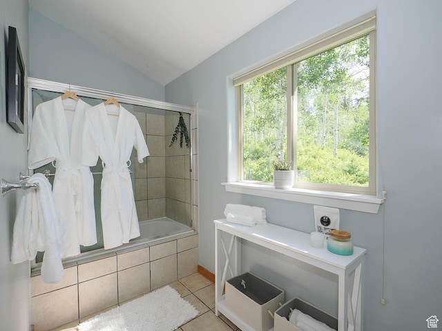 bathroom with tile patterned floors, tiled shower / bath combo, and vaulted ceiling