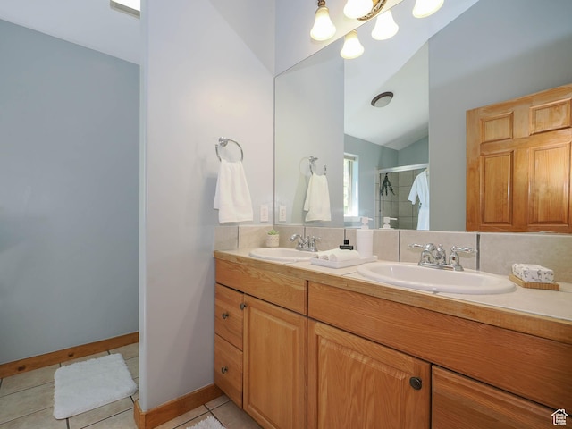 full bathroom with a shower stall, tile patterned floors, double vanity, and a sink