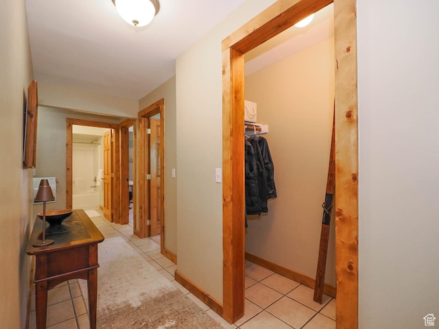 hall with light tile patterned floors and baseboards