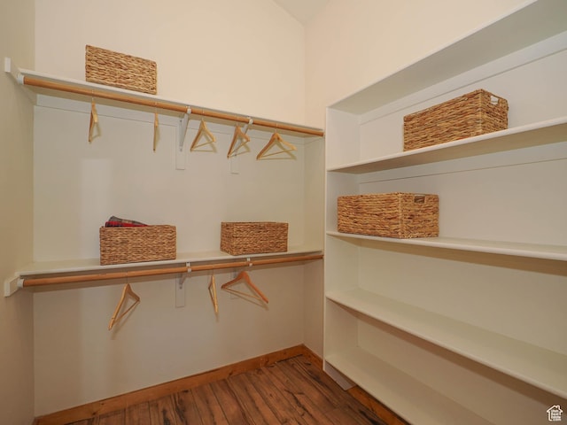 walk in closet with wood finished floors