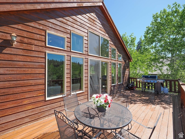 wooden deck featuring outdoor dining space and a grill