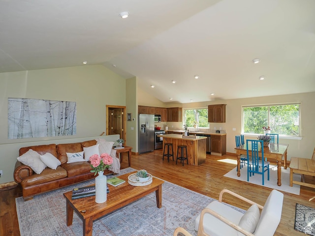 living room with recessed lighting, light wood finished floors, and vaulted ceiling