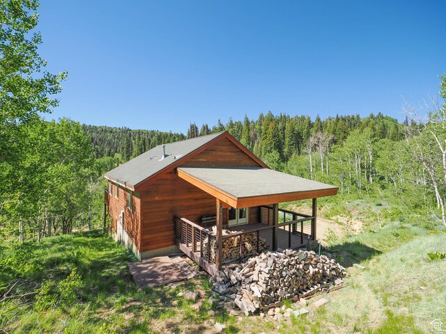 view of home's exterior featuring a wooded view, an exterior structure, and an outdoor structure