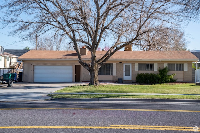 ranch-style house with brick siding, driveway, a chimney, and an attached garage