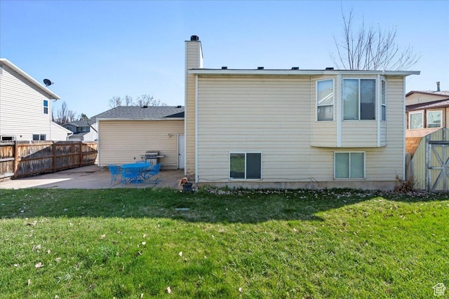 1107 E 2450 N, Layton, UT 84040 - rear view of property featuring a chimney, a patio area, a yard, fence, and a storage unit