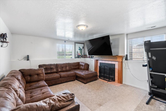 1107 E 2450 N, Layton, UT 84040 - carpeted living room featuring a textured ceiling, a tile fireplace, visible vents, and a wealth of natural light