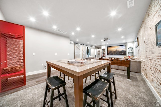 dining room with recessed lighting, a barn door, visible vents, and baseboards