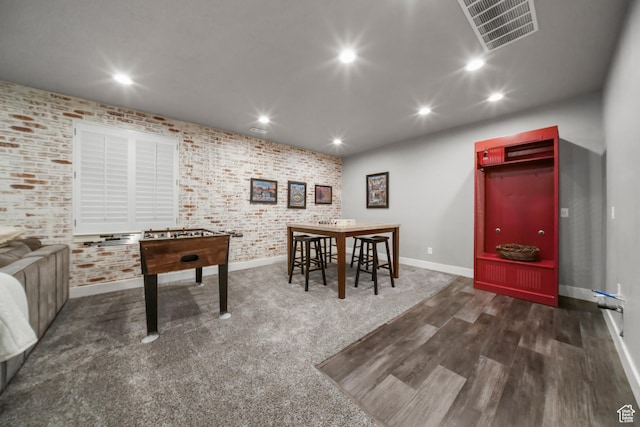 game room with visible vents, recessed lighting, wood finished floors, brick wall, and baseboards