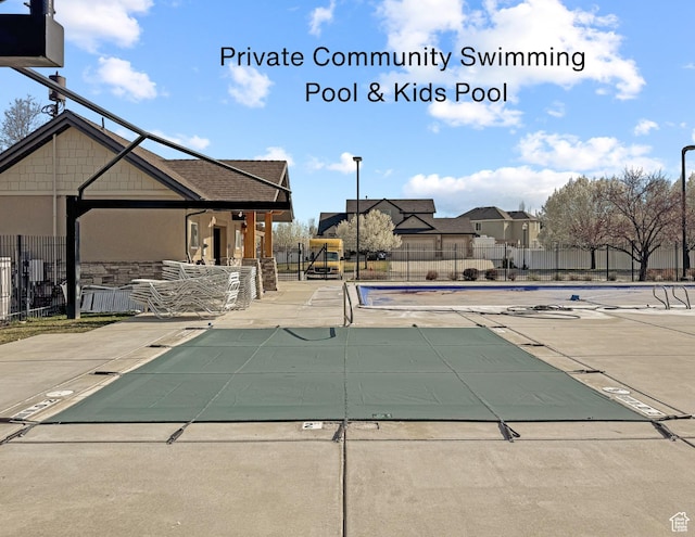 community pool with a patio and fence
