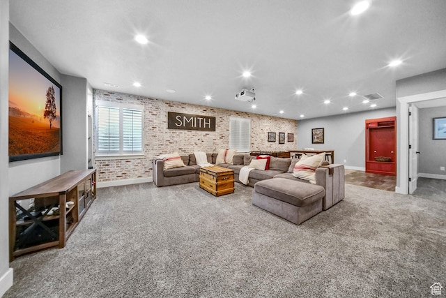 carpeted living room with visible vents, baseboards, recessed lighting, and brick wall
