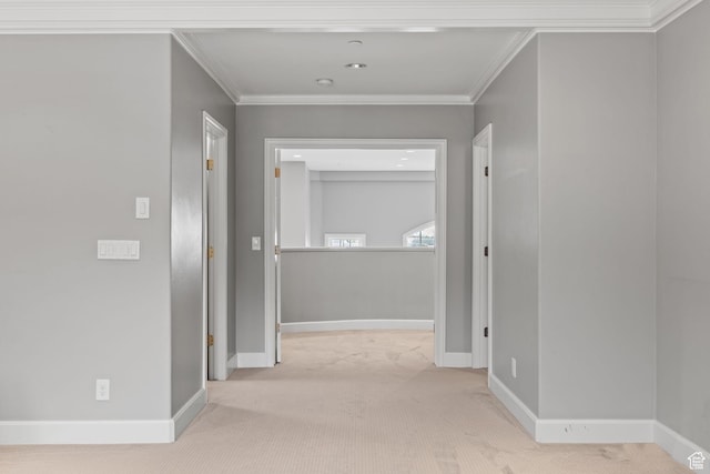hall featuring crown molding, baseboards, and carpet flooring