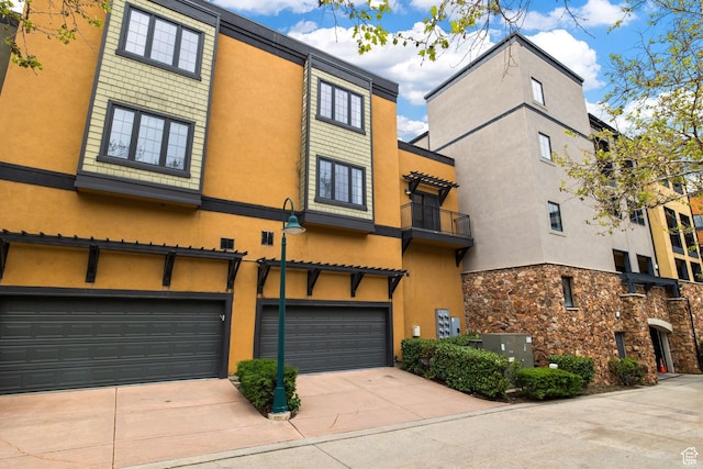 view of front of property featuring concrete driveway, stucco siding, and an attached garage
