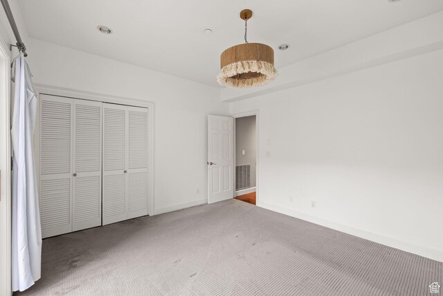 unfurnished bedroom with visible vents, a closet, baseboards, and carpet floors