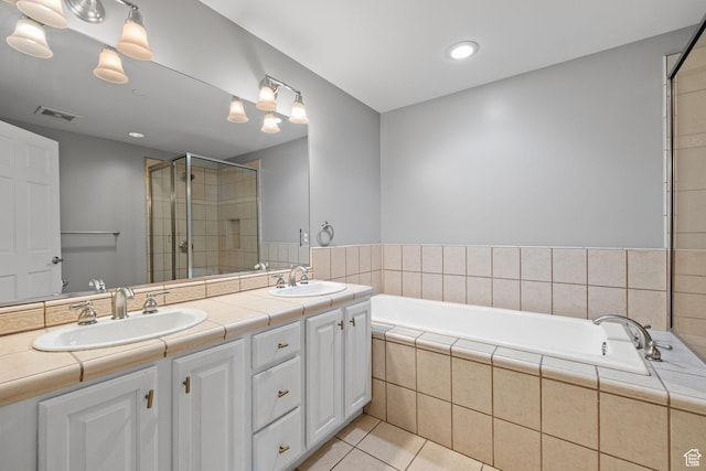 bathroom featuring a shower stall, a bath, a sink, and tile patterned flooring