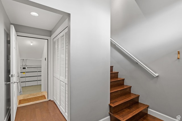 staircase featuring baseboards and wood finished floors