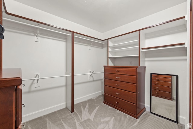 walk in closet featuring light carpet