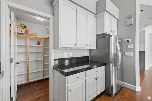 kitchen featuring dark wood-style flooring, white cabinets, dark countertops, and stainless steel refrigerator with ice dispenser