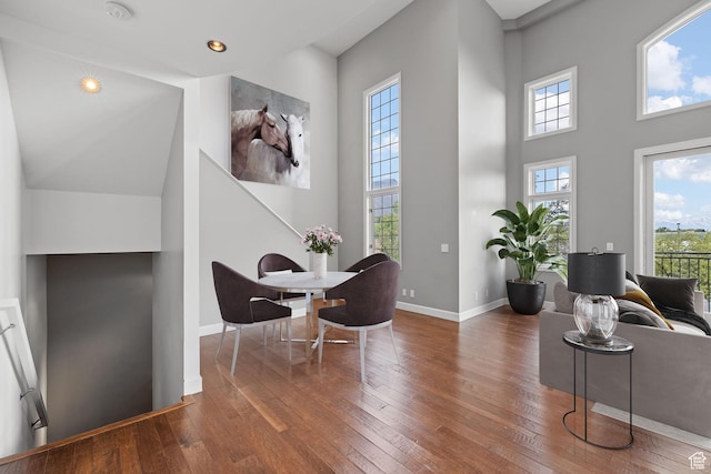interior space with a high ceiling, wood-type flooring, baseboards, and recessed lighting