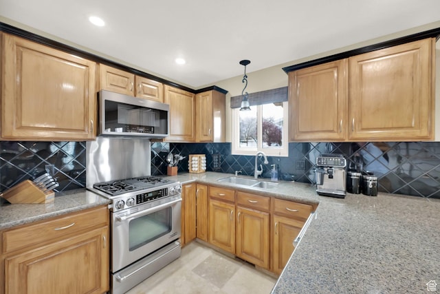 kitchen with light stone counters, a sink, hanging light fixtures, stainless steel appliances, and decorative backsplash