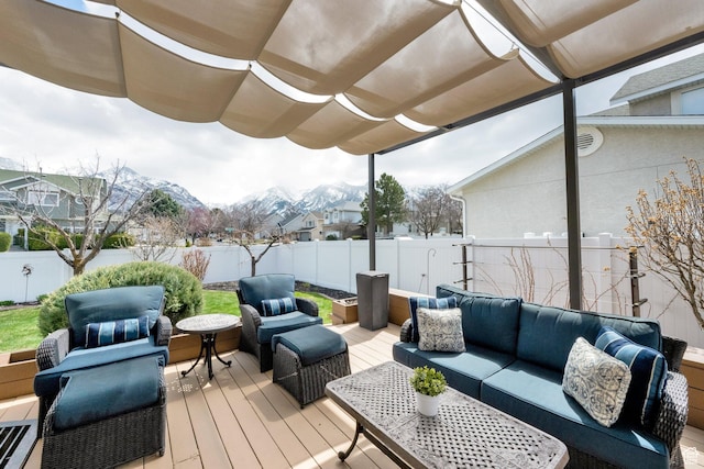 wooden deck featuring a pergola, an outdoor living space, a fenced backyard, and a mountain view