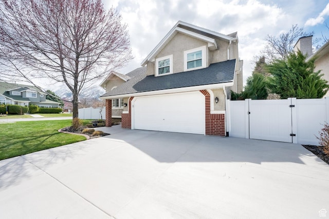 traditional-style house with brick siding, a garage, concrete driveway, and a gate