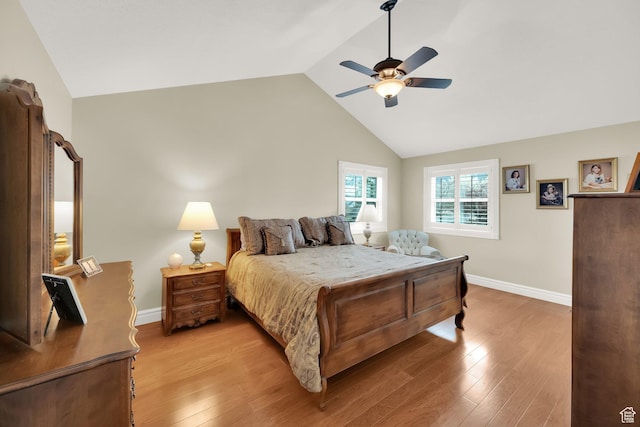 bedroom with light wood-style floors, baseboards, a ceiling fan, and vaulted ceiling