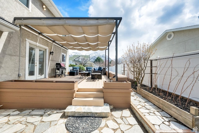 view of patio / terrace with a deck, french doors, and fence