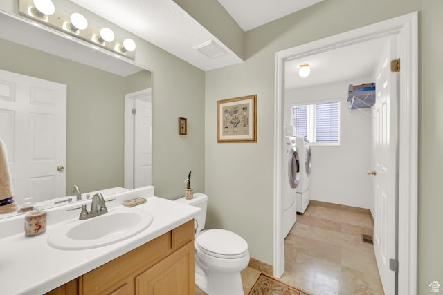 bathroom with visible vents, toilet, washing machine and dryer, and vanity