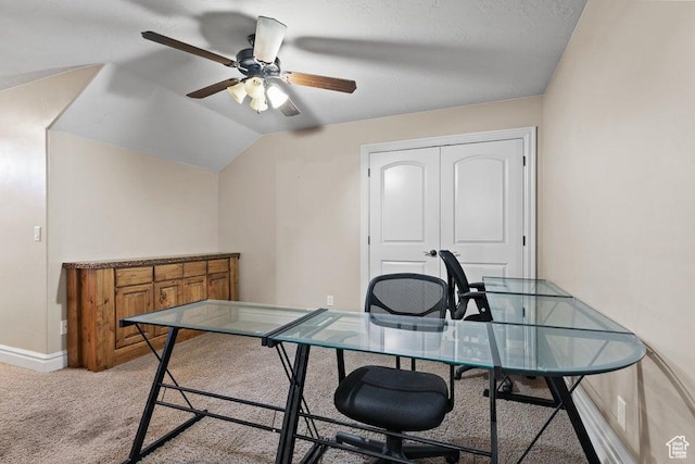 office area featuring baseboards, light colored carpet, a ceiling fan, and lofted ceiling
