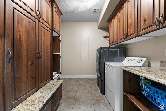 laundry area with visible vents, light tile patterned flooring, washer and dryer, baseboards, and cabinet space