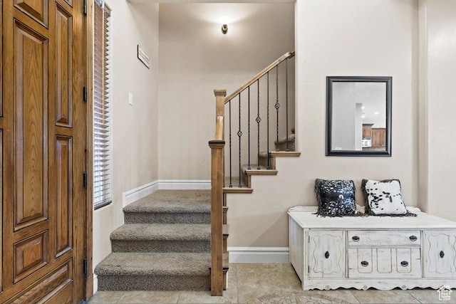 stairway with tile patterned floors and baseboards
