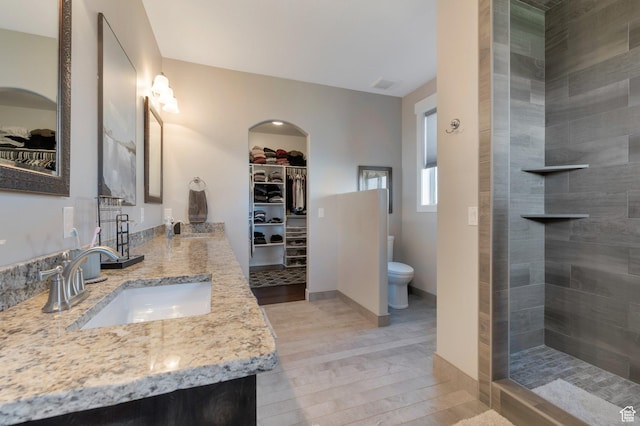 1737 E 6850 S, Uintah, UT 84405 - bathroom featuring toilet, a tile shower, double vanity, and a spacious closet