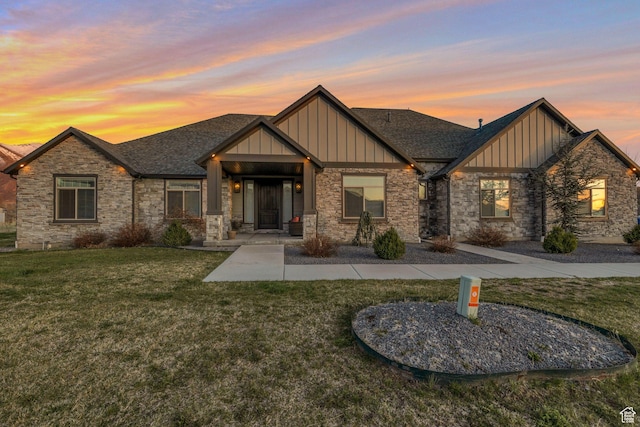 craftsman-style house featuring board and batten siding, stone siding, and a lawn