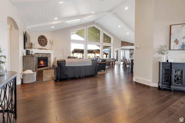 1737 E 6850 S, Uintah, UT 84405 - living area with plenty of natural light, beam ceiling, arched walkways, a lit fireplace, and dark wood-type flooring