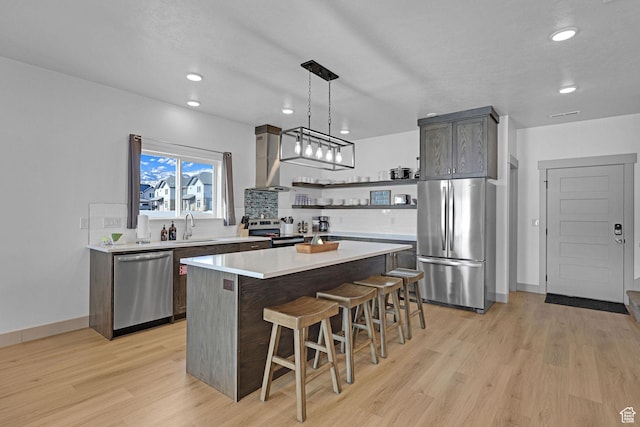 140 W 150 S Unit 22, Garden City, UT 84028 - kitchen with stainless steel appliances, a sink, open shelves, light wood-type flooring, and a breakfast bar