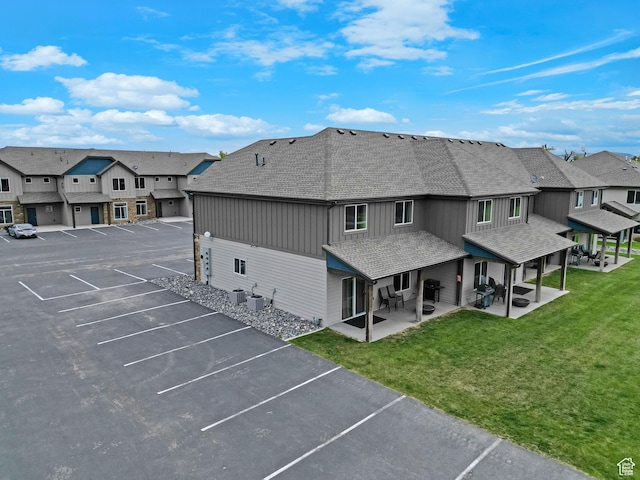 140 W 150 S Unit 22, Garden City, UT 84028 - back of house featuring uncovered parking, a shingled roof, a residential view, board and batten siding, and a patio area