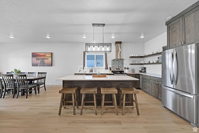 140 W 150 S Unit 22, Garden City, UT 84028 - kitchen featuring stainless steel appliances, open shelves, wall chimney range hood, a center island, and light countertops