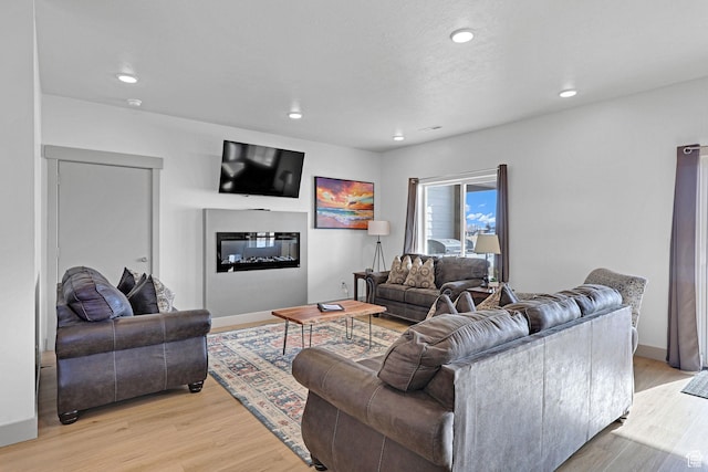 140 W 150 S Unit 22, Garden City, UT 84028 - living room with light wood finished floors, recessed lighting, a glass covered fireplace, and baseboards