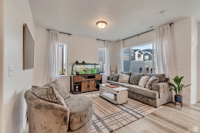 living room with light wood-style flooring and visible vents