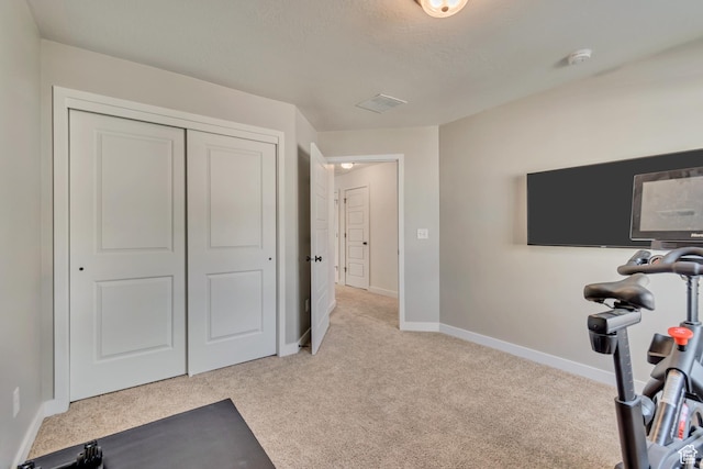 workout room featuring carpet flooring, visible vents, and baseboards