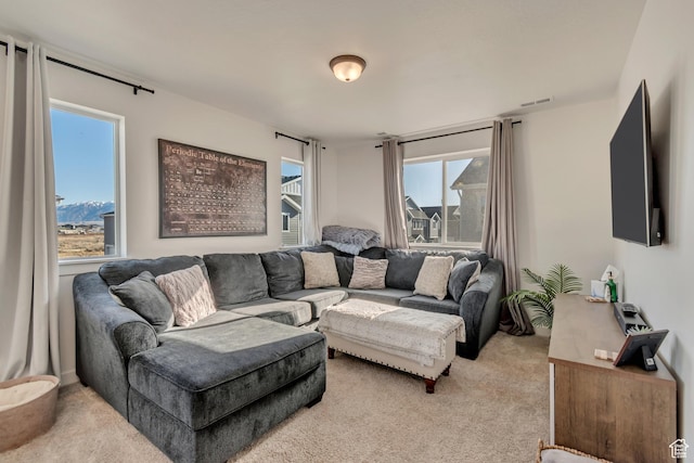 living room featuring visible vents, light carpet, and a healthy amount of sunlight