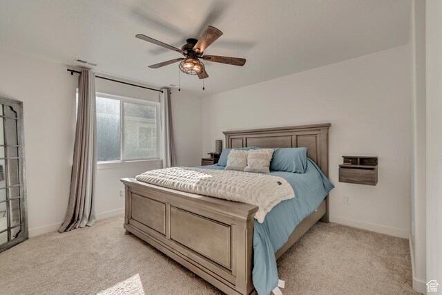 bedroom with visible vents, baseboards, a ceiling fan, and light carpet