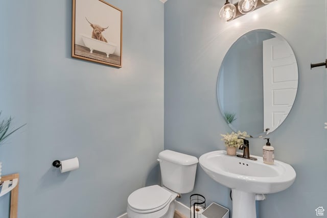 half bath with baseboards and toilet