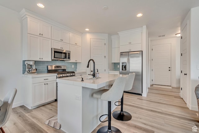 kitchen featuring white cabinets, light wood-style floors, and stainless steel appliances