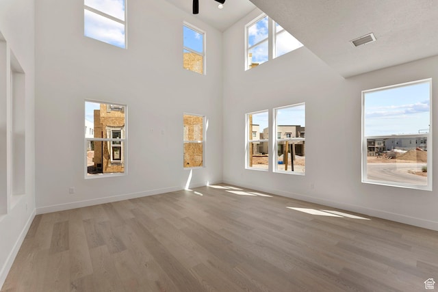 516 W Olive Ln, St George, UT 84790 - unfurnished living room featuring light wood finished floors, a ceiling fan, and a towering ceiling