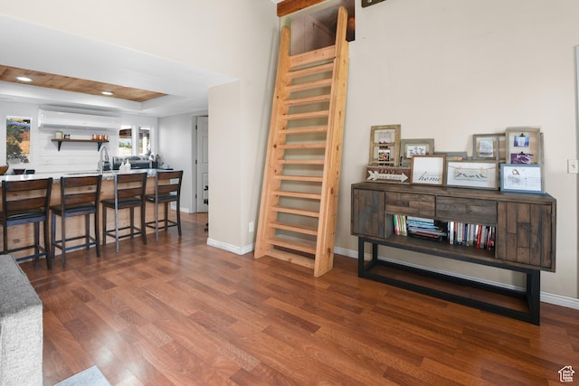 interior space with a raised ceiling, wood finished floors, baseboards, and recessed lighting