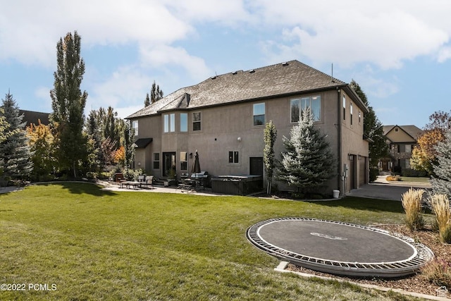 923 Ledgestone Ln, Heber City, UT 84032 - back of house featuring a trampoline, a patio area, stucco siding, and a lawn