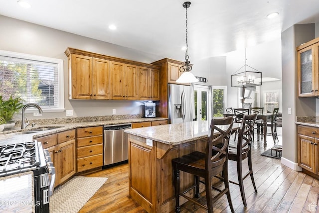 923 Ledgestone Ln, Heber City, UT 84032 - kitchen featuring a center island, a sink, light wood-type flooring, stainless steel appliances, and light stone counters