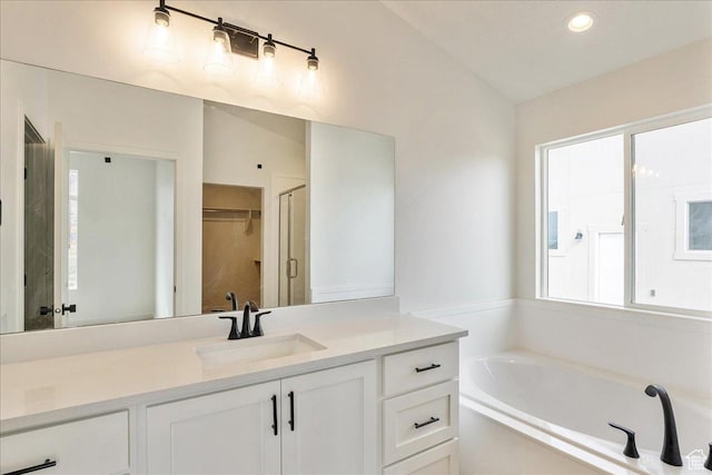 2329 E Woodbury Ln, Eagle Mountain, UT 84005 - bathroom with recessed lighting, vanity, vaulted ceiling, and a garden tub