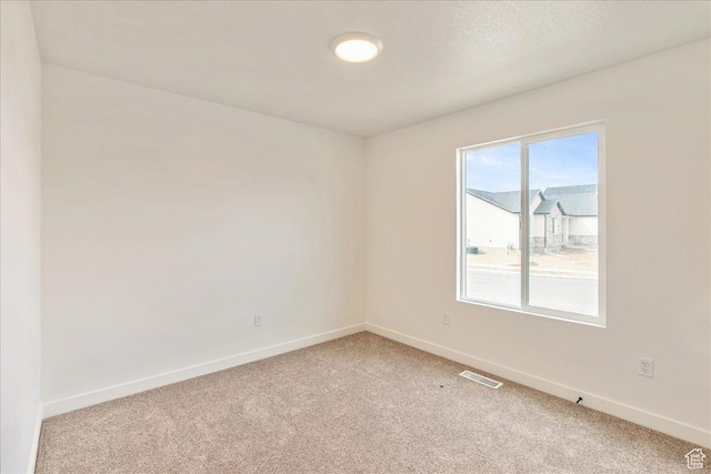 2329 E Woodbury Ln, Eagle Mountain, UT 84005 - unfurnished room with visible vents, baseboards, light carpet, and a textured ceiling